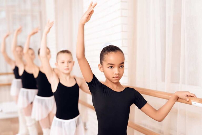 Parent helping a child organize dance shoes and clothing before class.
